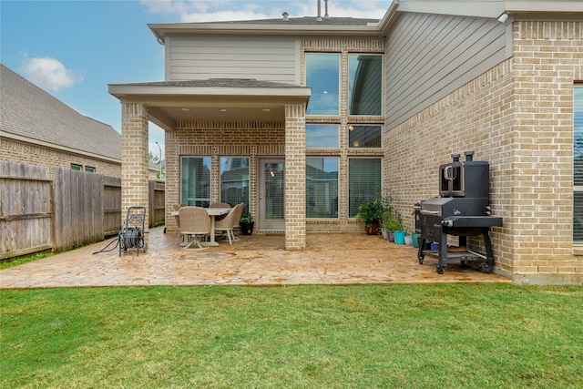 rear view of property featuring a patio and a yard