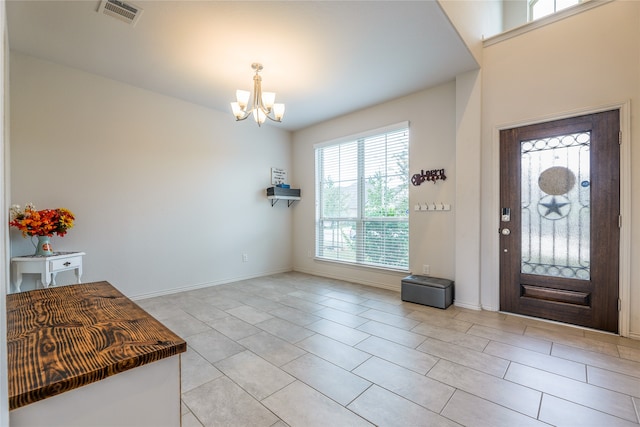 entryway with a chandelier and light tile patterned floors