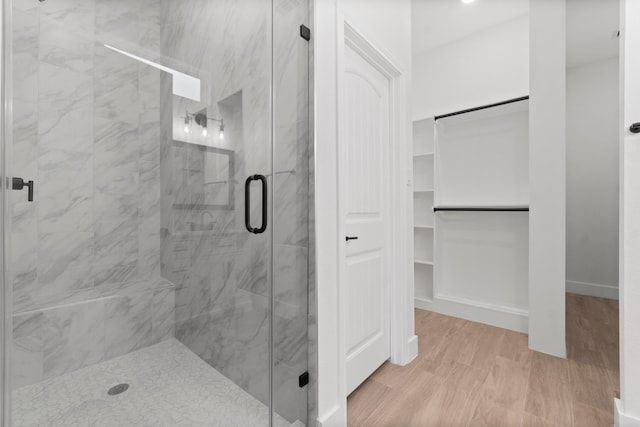 bathroom featuring hardwood / wood-style floors and a shower with door