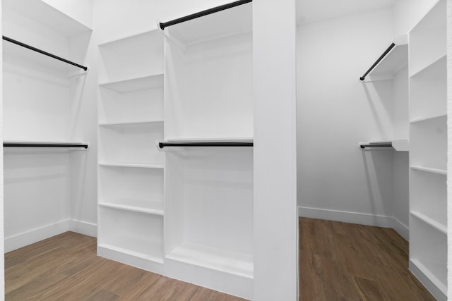 walk in closet with dark wood-type flooring