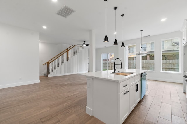 kitchen featuring a center island with sink, sink, light hardwood / wood-style flooring, and white cabinetry