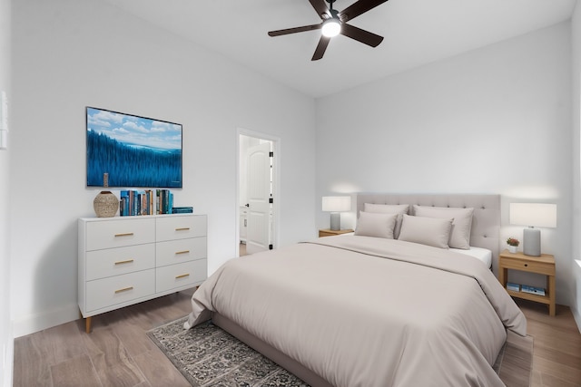 bedroom with ensuite bathroom, light wood-type flooring, and ceiling fan