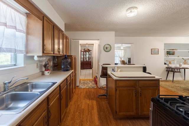 kitchen featuring a wealth of natural light, dark hardwood / wood-style floors, sink, and a center island