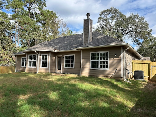 rear view of property featuring central AC unit and a yard