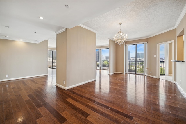 empty room featuring ornamental molding, dark hardwood / wood-style flooring, and an inviting chandelier