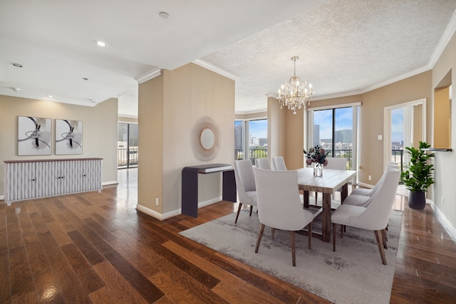 dining area featuring dark hardwood / wood-style flooring, a chandelier, a textured ceiling, and ornamental molding