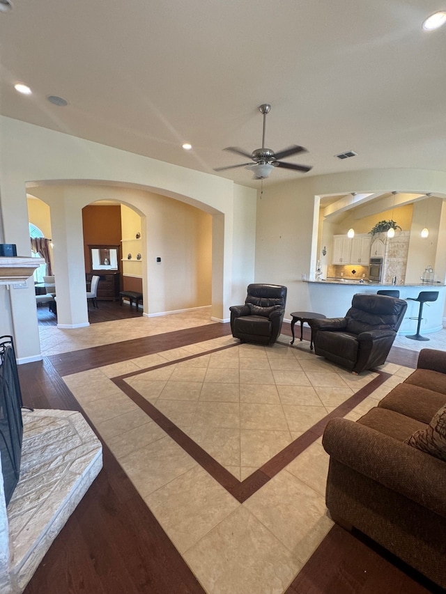 living room featuring light hardwood / wood-style flooring and ceiling fan