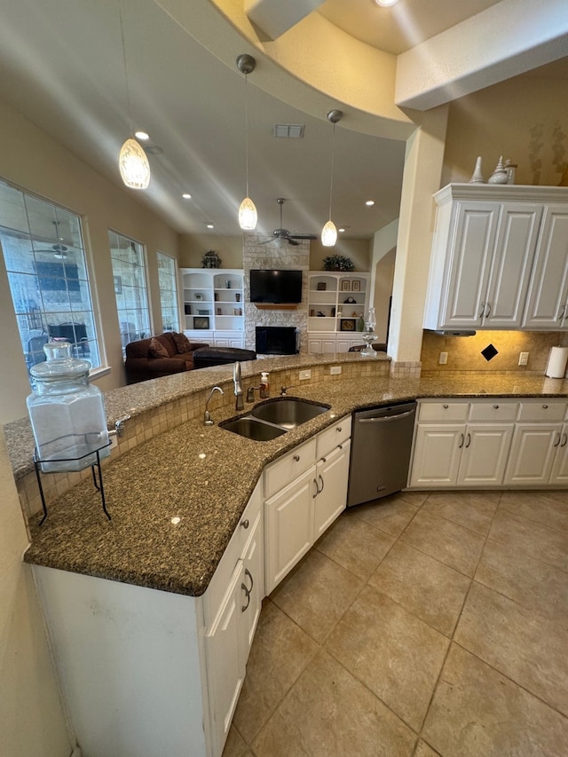 kitchen featuring white cabinets, hanging light fixtures, stainless steel dishwasher, and dark stone countertops