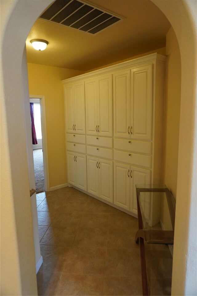 6016 Fm 2720, Maxwell, TX 78656 - hall featuring arched walkways, baseboards, and light tile patterned floors
