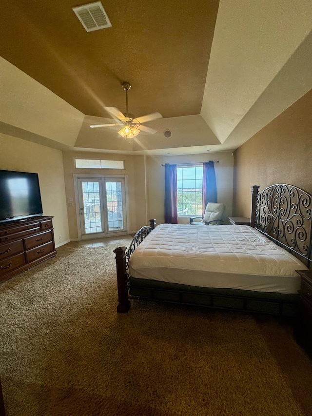 carpeted bedroom with ceiling fan, a textured ceiling, and a raised ceiling