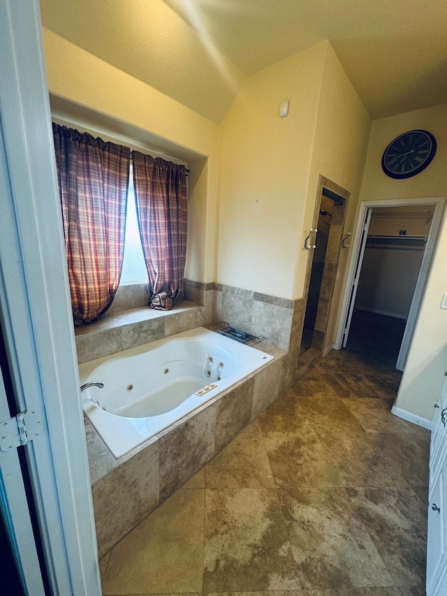 bathroom featuring independent shower and bath and vaulted ceiling