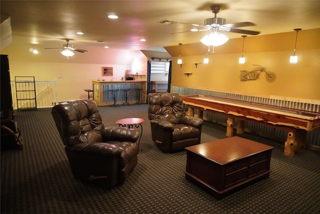 home theater with bar area, ceiling fan, and dark carpet