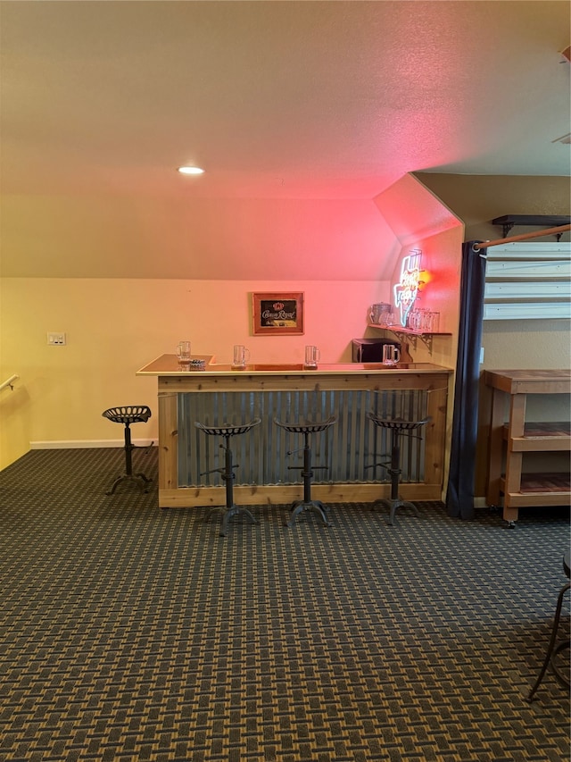 bonus room featuring dark colored carpet and lofted ceiling