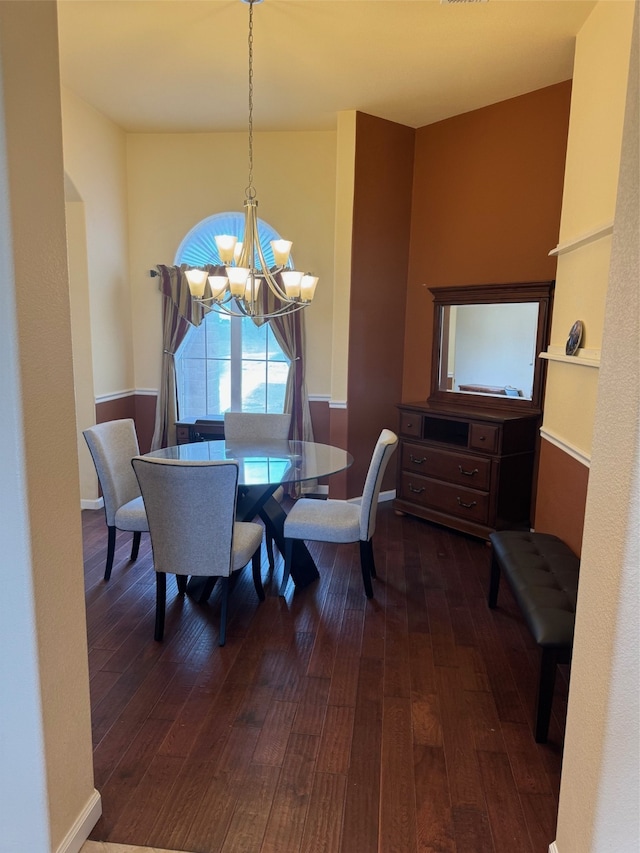 dining area with a notable chandelier and dark hardwood / wood-style floors