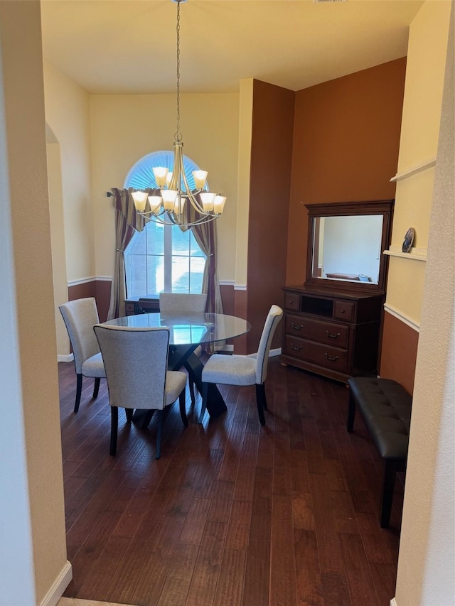 6016 Fm 2720, Maxwell, TX 78656 - dining area featuring a chandelier, dark wood finished floors, arched walkways, and baseboards