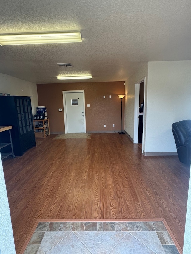 unfurnished living room featuring a textured ceiling and hardwood / wood-style flooring