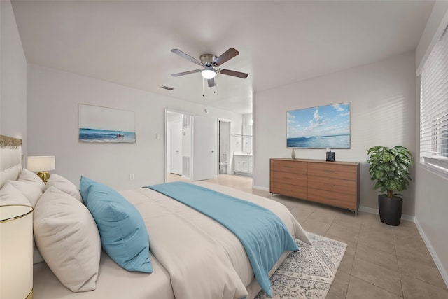 bedroom with light tile patterned floors, ceiling fan, and ensuite bath