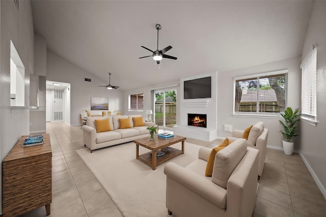 living room with ceiling fan, light tile patterned floors, a large fireplace, and high vaulted ceiling