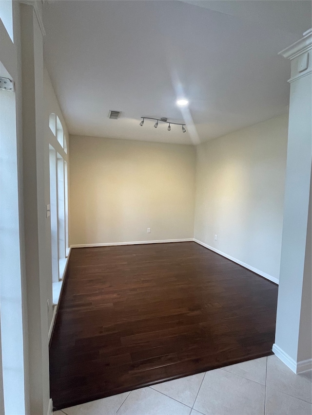 spare room featuring light wood-type flooring and rail lighting