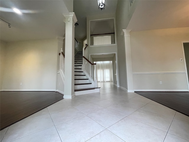 entryway with a towering ceiling and light tile patterned floors