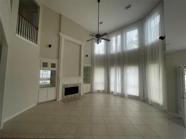 unfurnished living room featuring a towering ceiling, a healthy amount of sunlight, and light tile patterned flooring