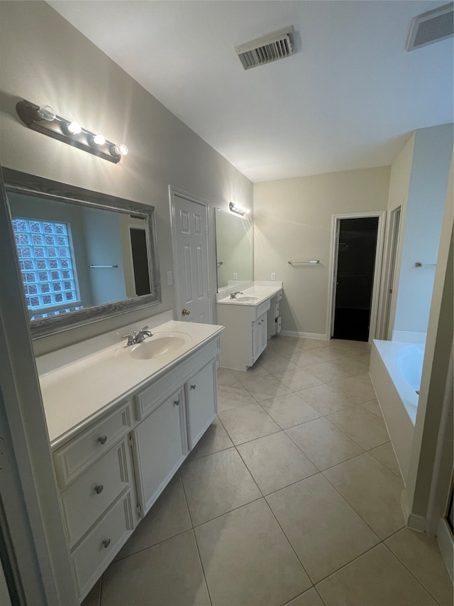 bathroom featuring vanity, tile patterned flooring, and a bathing tub