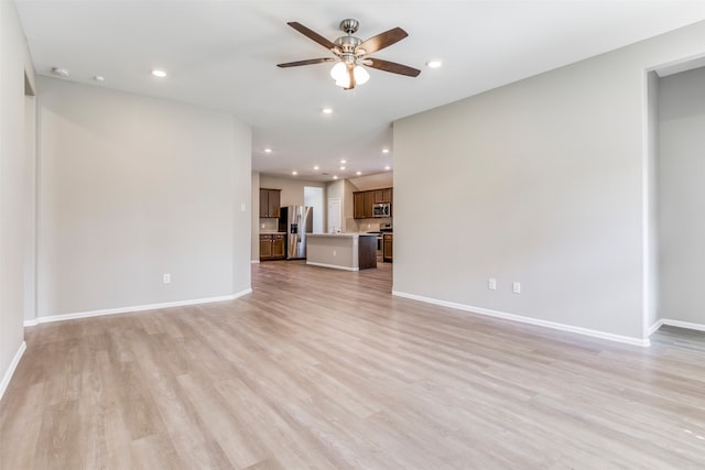 unfurnished living room featuring light wood-type flooring and ceiling fan