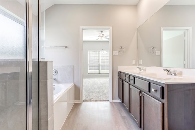 bathroom featuring lofted ceiling, a washtub, hardwood / wood-style flooring, vanity, and ceiling fan