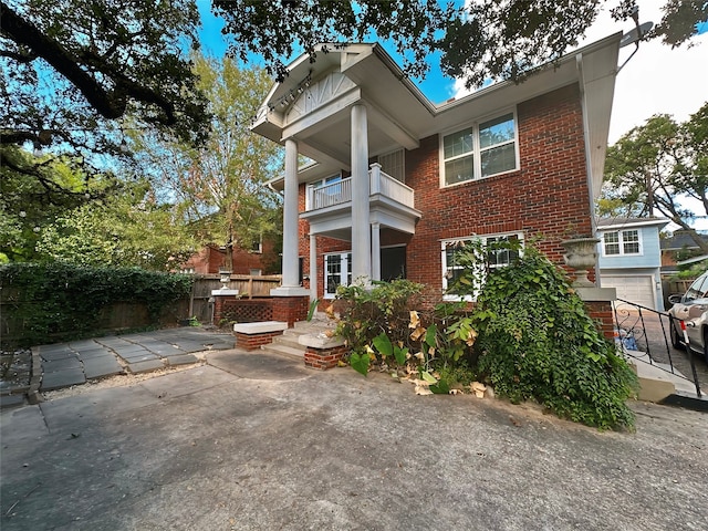 back of property with a garage and a balcony