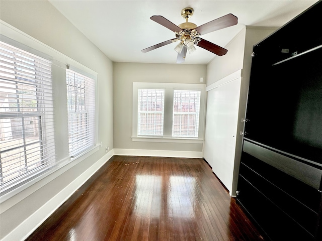 interior space with dark wood-type flooring and ceiling fan