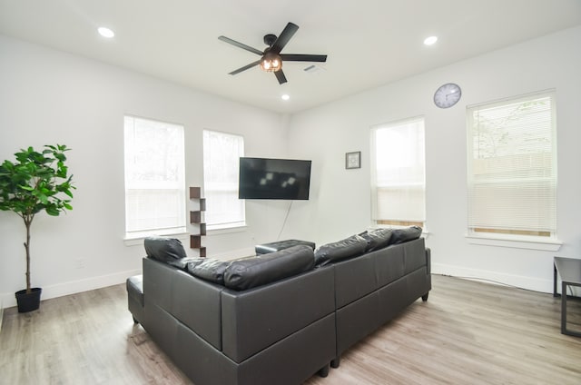 living room with light wood-type flooring, a wealth of natural light, and ceiling fan