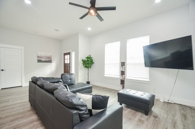 living room with plenty of natural light, ceiling fan, and light hardwood / wood-style flooring