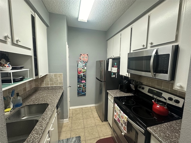 kitchen with stainless steel appliances, white cabinetry, sink, a textured ceiling, and decorative backsplash