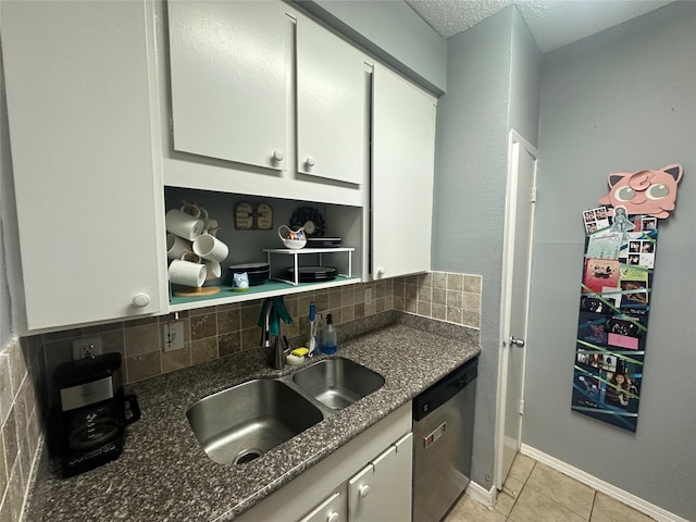 kitchen featuring stainless steel dishwasher, light tile patterned floors, sink, and tasteful backsplash