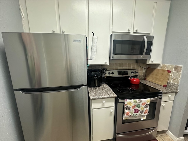 kitchen with white cabinets, appliances with stainless steel finishes, and backsplash