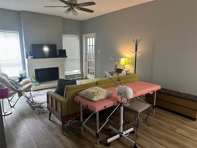 living room featuring a textured ceiling, hardwood / wood-style flooring, and ceiling fan