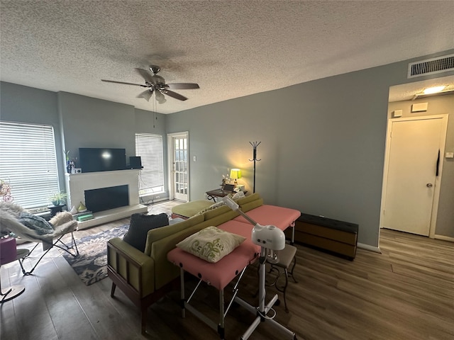 bedroom with dark hardwood / wood-style flooring, a textured ceiling, and ceiling fan