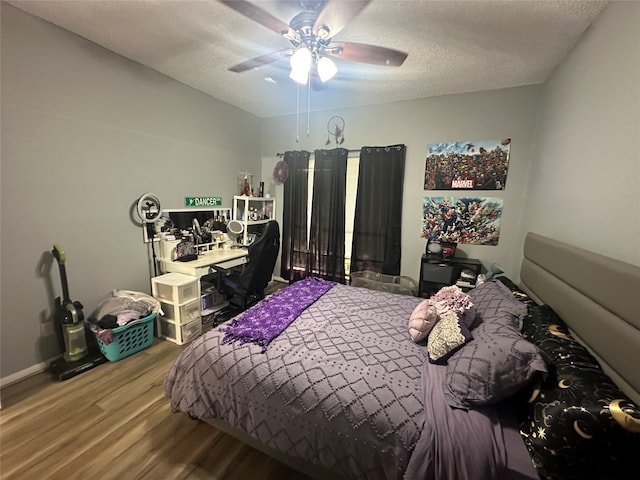 bedroom with ceiling fan, a textured ceiling, and wood-type flooring