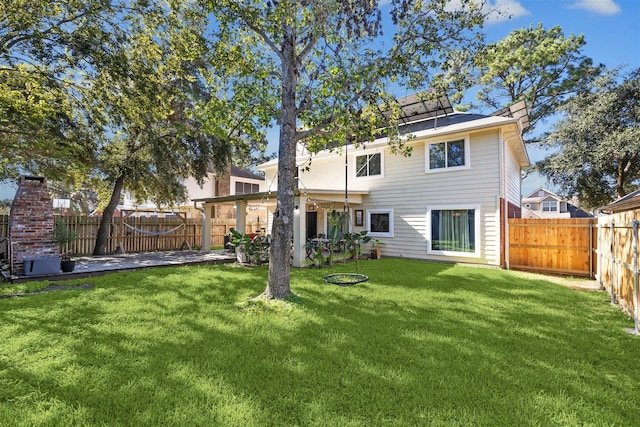 rear view of property featuring a patio area and a yard