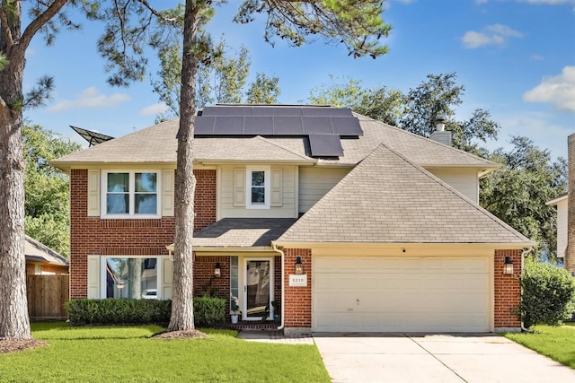 view of front of house with a garage, a front lawn, and solar panels