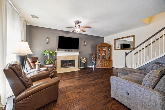 living room featuring ceiling fan, dark hardwood / wood-style flooring, and a textured ceiling