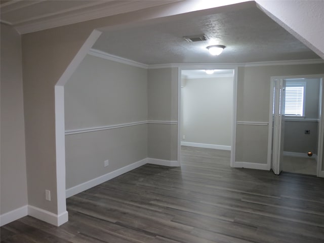 unfurnished room featuring dark hardwood / wood-style flooring, a textured ceiling, and ornamental molding