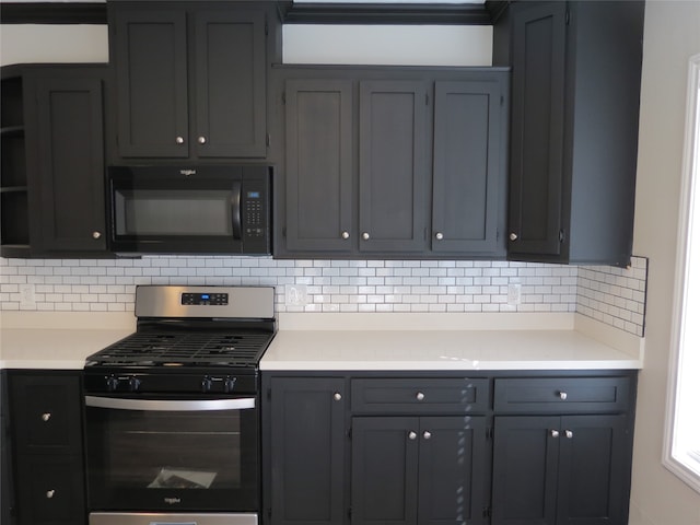 kitchen with gray cabinetry, decorative backsplash, and stainless steel gas range oven