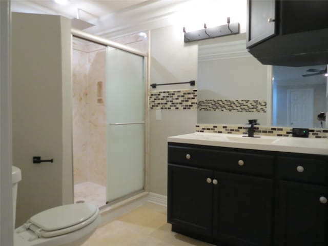 bathroom with toilet, tile patterned flooring, vanity, backsplash, and a shower with shower door