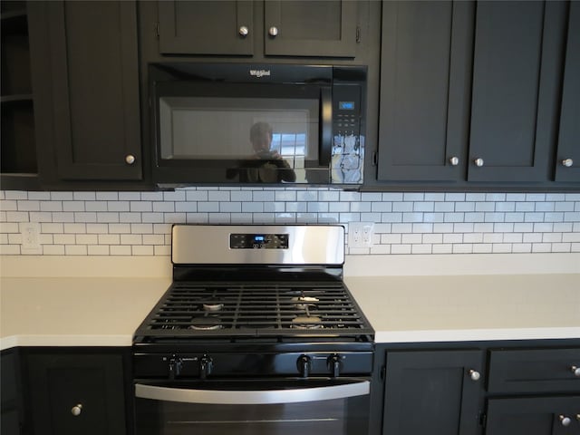 kitchen with stainless steel gas stove and tasteful backsplash