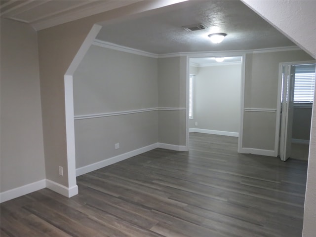 interior space featuring dark wood-type flooring, a textured ceiling, and crown molding