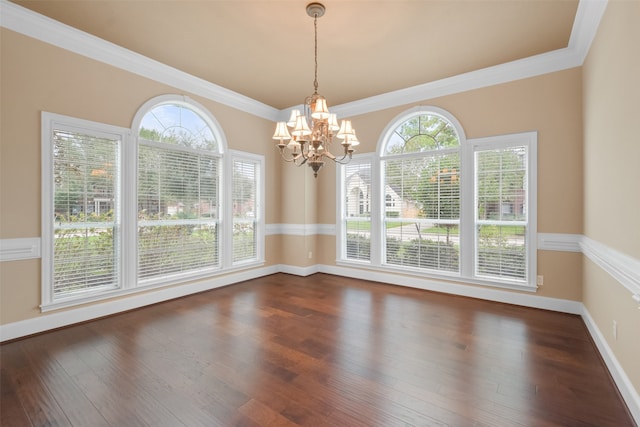 unfurnished dining area featuring ornamental molding, dark wood-type flooring, and a notable chandelier