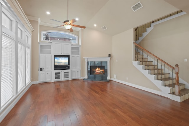 unfurnished living room with crown molding, a fireplace, high vaulted ceiling, hardwood / wood-style floors, and ceiling fan