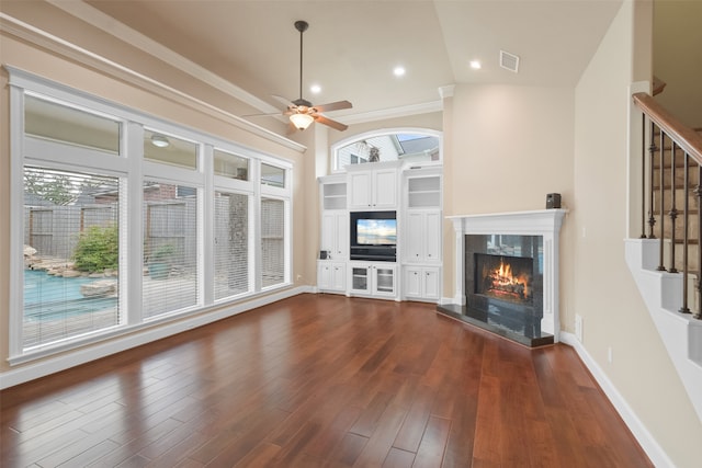 unfurnished living room featuring ornamental molding, dark hardwood / wood-style floors, vaulted ceiling, a tile fireplace, and ceiling fan