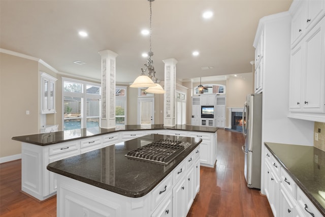 kitchen featuring stainless steel refrigerator, ornamental molding, decorative light fixtures, and a center island